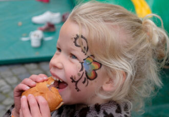 Lachende geschminkte gezichten tijdens Koningsdag Ootmarsum